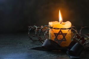 Mémorial de l'Holocauste éclairé par une lumière douce au crépuscule avec des fleurs et des bougies